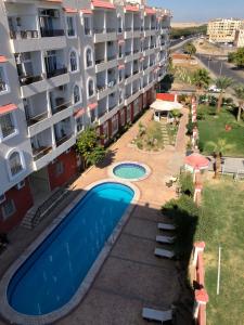 an apartment building with a swimming pool next to a building at Hurghada Village sea view in Hurghada