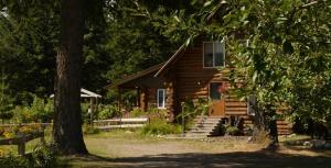 uma cabana de madeira com um alpendre e escadas para a porta em Cedar Mountain Farm Bed and Breakfast LLC em Athol