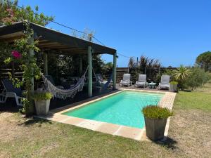 a swimming pool in a backyard with a gazebo at Los Pecados de la Viuda in Punta Del Diablo