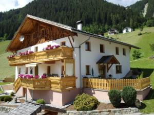 a small white house with a wooden balcony at Temelerhof in Gries im Sellrain