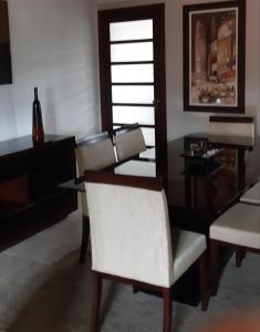 un comedor con una silla blanca y una mesa en Apartamento completo, en São Lourenço