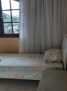 1 dormitorio con cama y ventana en Apartamento completo en São Lourenço