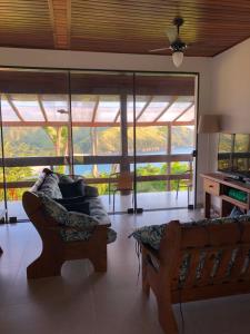 ein Wohnzimmer mit einem Sofa, einem Tisch und Fenstern in der Unterkunft Casa praia vista mar ttg in Toque Toque Grande