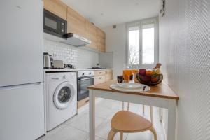 una cocina con una mesa con un bol de fruta. en Bee Home Metro 7 + RER C + Easy Check-in + Parking, en Ivry-sur-Seine