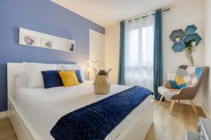 Un dormitorio con una cama con paredes azules y una silla en Bee Home Metro 7 + RER C + Easy Check-in + Parking, en Ivry-sur-Seine