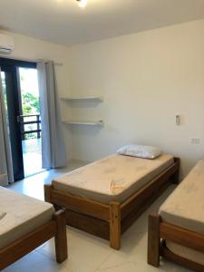 1 Schlafzimmer mit 2 Betten und einer Tür zu einem Balkon in der Unterkunft Casa praia vista mar ttg in Toque Toque Grande + 63 Fotos