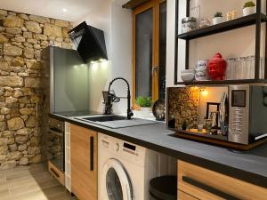 a kitchen with a sink and a washing machine at Dormelles : magnifique maison de ville in Dormelles