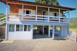 a house with a balcony and a garage at Sitio Rio Cachimbo in Urubici