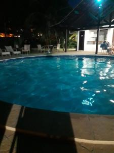 een groot blauw zwembad 's nachts bij Duplex em Praia do Forte a 50m da vila in Mata de Sao Joao