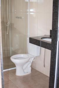 a bathroom with a white toilet and a sink at Chalés Cantin da Serra - Serra da Canastra/MG in São Roque de Minas