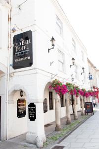 un viejo hotel con flores en una calle en The Old Bell - Warminster, en Warminster