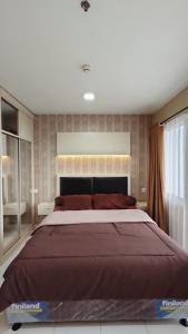 um quarto com uma cama grande num quarto em Kozy Room Sentul Tower Apartemen em Bogor