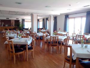 a dining room with white tables and wooden chairs at Hotel Mirafresno in Miranda do Douro