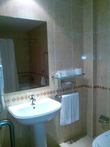 a bathroom with a sink and a mirror and a toilet at Hotel Mirafresno in Miranda do Douro +25 photos