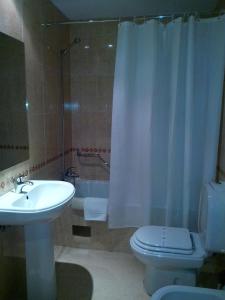 een badkamer met een wastafel, een toilet en een douche bij Hotel Mirafresno in Miranda do Douro