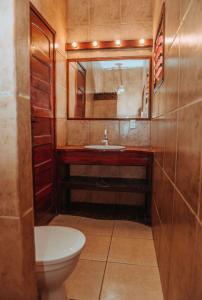 uma casa de banho com um WC, um lavatório e um espelho. em Vila Moana Jeri em Jericoacoara