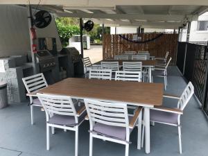 a group of tables and chairs on a patio at Cocos Holiday Apartments in Trinity Beach