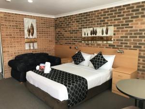 a hotel room with a bed and a couch at Jumbuck Motor Inn in Tenterfield