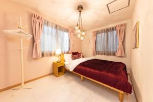 a bedroom with a bed and a chandelier at Y's HOTEL KAMEARI in Tokyo