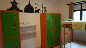 a room with two green and red lockers and a bed at The backpack hub at weligama in Weligama