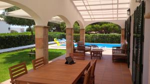 a patio with a table and chairs and a pool at Villa Violeta in Cala en Blanes