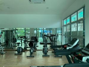 a gym with a bunch of treadmills and machines at Der’s Apartment in Bandar Penawar