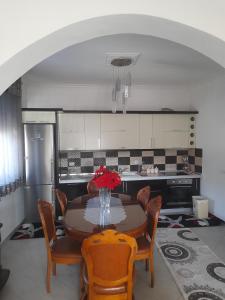a kitchen with a table with chairs and a refrigerator at Vila Xhipe in Korçë