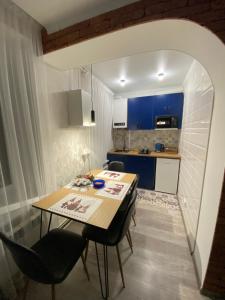 een keuken met een tafel en stoelen in een kamer bij Люкс апартаменти «Д.І.М.» in Kamjanets-Podilsky