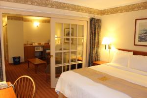 a hotel room with a bed and a desk at Coastal Inn Halifax - Bayers Lake in Halifax +18 photos