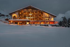 ein großes Gebäude im Schnee in der Nacht in der Unterkunft Hotel & Chalet Montana in Lech am Arlberg