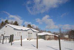 遠輕町的住宿－Tarochan House，雪中带栅栏的白色房子