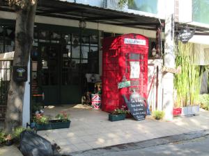 a red phone booth sitting outside of a building at The London Tearoom in Chiang Mai