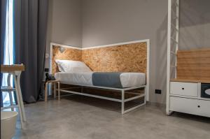 1 dormitorio con 1 cama con cabecero de madera en Residence Hotel Moderno en Bari