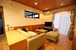 sala de estar con sofá y TV en 白浜ホープヒルズ　G-60, en Shirahama