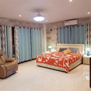 a bedroom with a bed and a chair and windows at Bula Harbour Resort Home (CFC Certified) Exclusive in Pacific Harbour