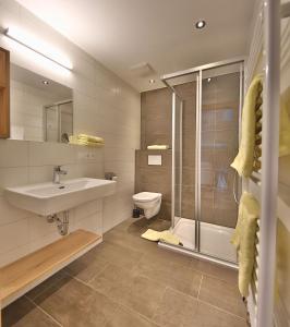 W łazience znajduje się umywalka, toaleta i prysznic. w obiekcie Arvenhof w mieście Serfaus