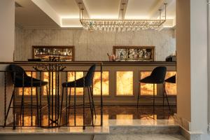 a bar with black stools in a room at The Gomerino Hotel in Valletta