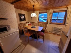 Una cocina con mesa y sillas y un refrigerador. en Gästehaus Bergwald - Pötscherjahringerhof, en Virgen