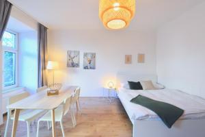 biała sypialnia z łóżkiem i stołem w obiekcie Perfect for Families and Mid-Term-Stays w Wiedniu