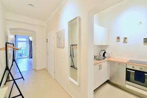 kuchnia z białymi szafkami i blatem w obiekcie Perfect for Families and Mid-Term-Stays w Wiedniu