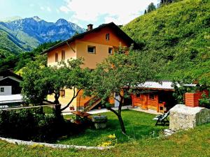 a house on a hill with mountains in the background at Apartment and Garden house among the mountains in Podbrdo