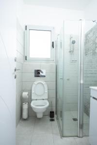 Un baño con inodoro y ducha de cristal. en PORT CITY HAIFA - German Colony Luxurious 2 bdrms Apt - MAMAD, en Haifa 73 fotos más