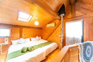 a bedroom with a bed in a wooden cabin at Awaji Seaside Log House in Awaji