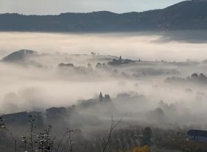 a view of a foggy city with buildings in the background at Casa Branzele in Trezzo Tinella