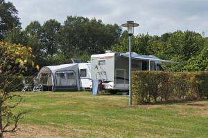 uma caravana e uma tenda estacionada num campo em De Huttert- Salland Stee em Luttenberg