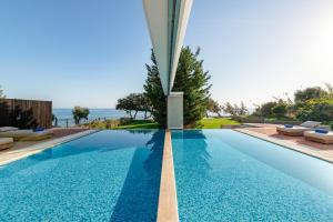 a swimming pool with a view of the ocean at Villa Kivotos in Lartos