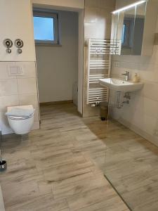 ein Badezimmer mit Toilette und Waschbecken in der Unterkunft Ferienwohnung Am Südhang in Göhren