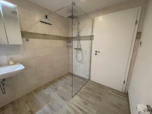 eine Dusche mit Glastür neben einem Waschbecken in der Unterkunft Ferienwohnung Am Südhang in Göhren