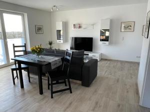 ein Wohnzimmer mit Tisch und Couch in der Unterkunft Ferienwohnung Am Südhang in Göhren