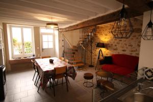 a living room with a table and a red couch at Gîte le Pilon in Verdon